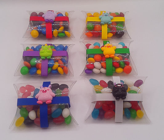 Monster charm with a clear pillow shaped box filled with lollies